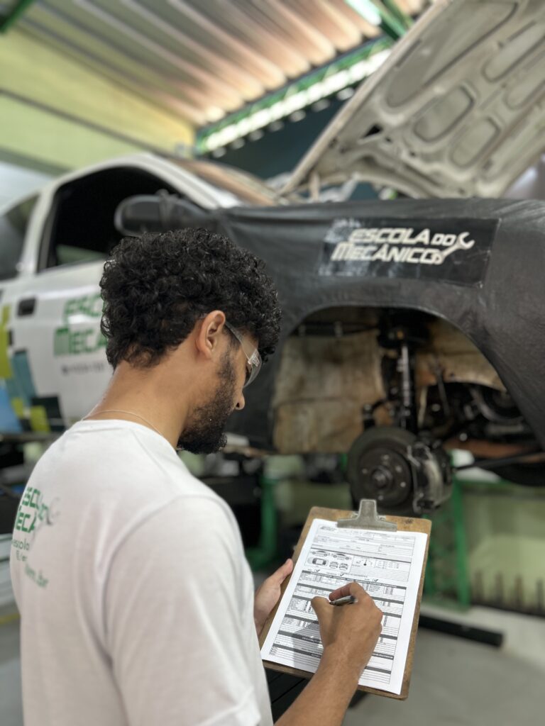 Mecânico profissional realizando a inspeção de discos e pastilhas de freio de um veículo.