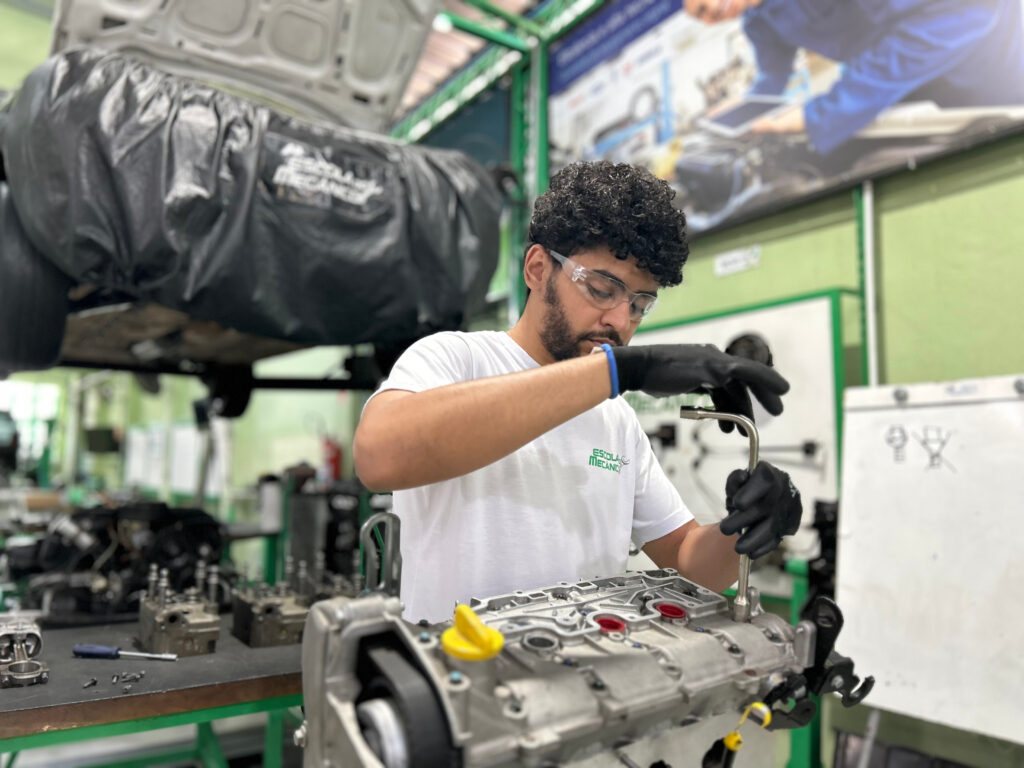 Mecânico automotivo realizando reparo em motor dentro da oficina
