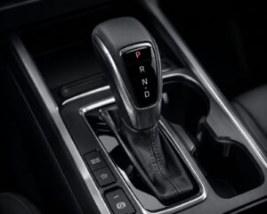 Vista da manopla de um câmbio automático moderno em console central de veículo, mostrando o seletor com as letras P, R, N, D.
