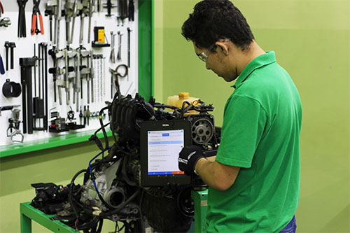 Eletricista automotivo realizando o diagnóstico no sistema elétrico de um veículo.
