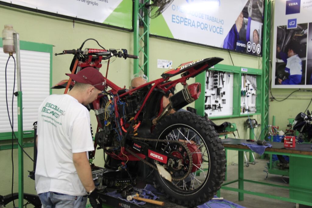 Profissional fazendo o diagnóstico do sistema de injeção eletrônica em uma moto na oficina.